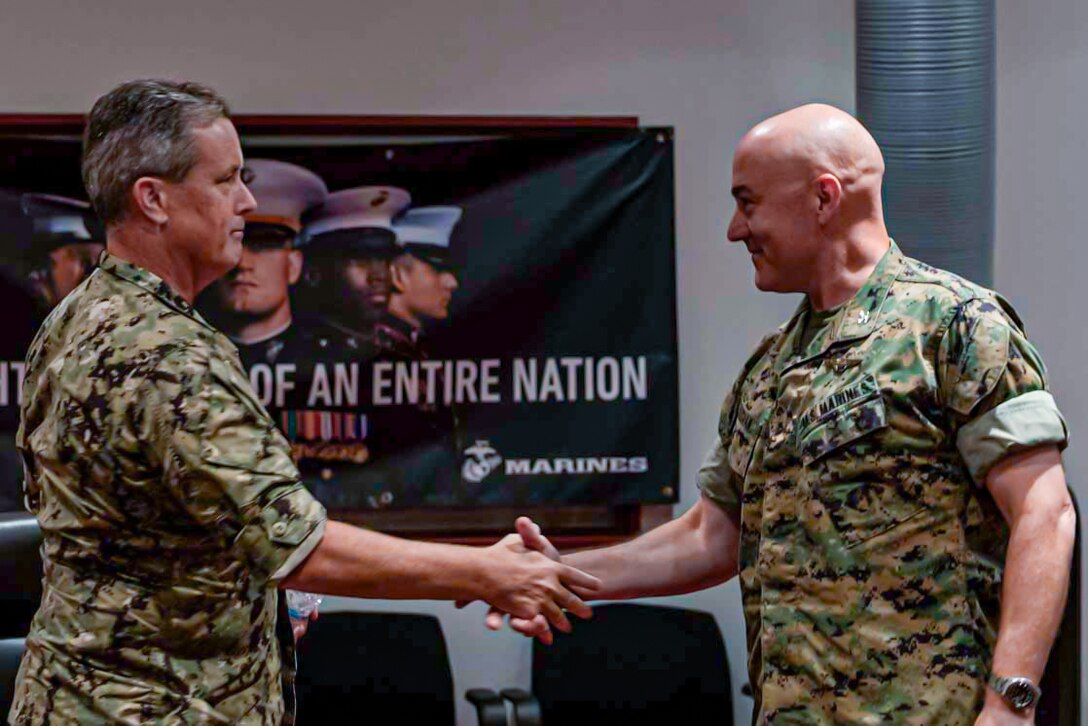 U.S. Navy Rear Adm. Anthony Rossi, Commander of Fleet Readiness Center, left, shakes hands with U.S. Marine Corps Col. Kenneth Rossman, commanding officer of Marine Corps Air Station Iwakuni, Japan, Jul. 28, 2025. Rear Adm. Rossi and his staff visited MCAS Iwakuni while touring the Indo-Pacific. (U.S. Marine Corps photo by Cpl. Dahkareo Pritchett)