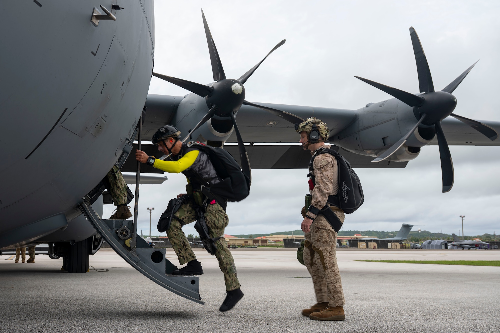Navy and Marine Corps members load onto an aircraft.