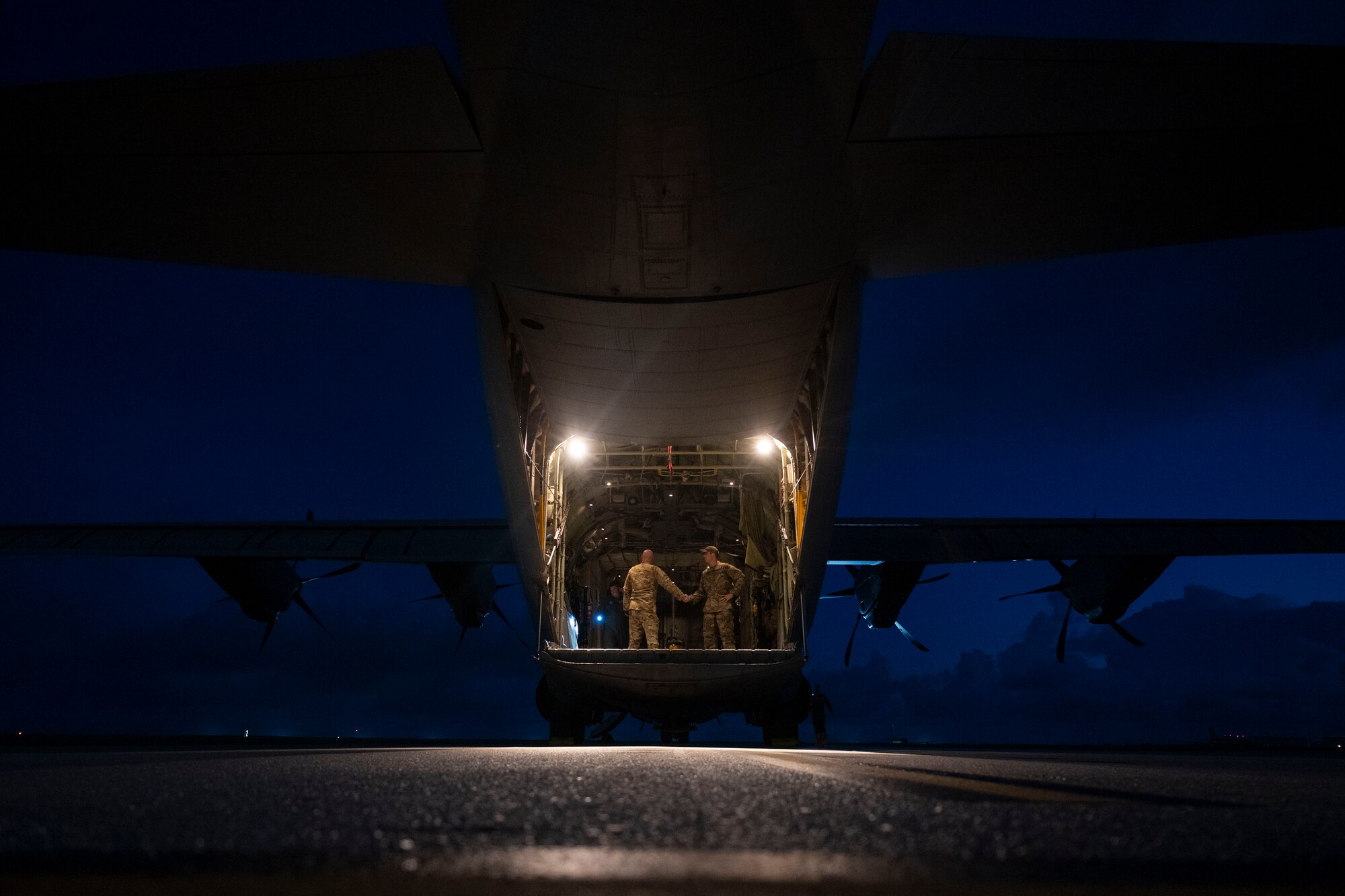 Aircrew conduct pre-flight checks at the back of an aircraft.