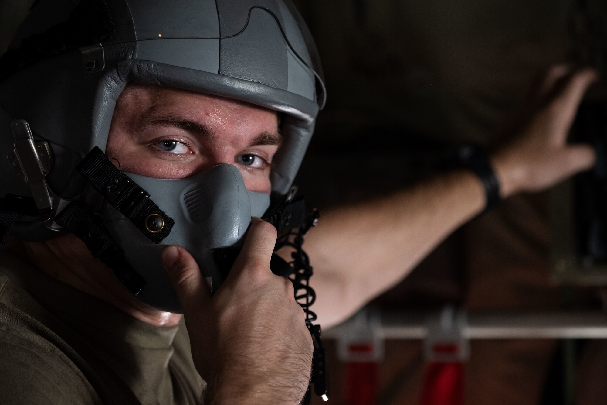 A loadmaster dons an oxygen mask before flight.