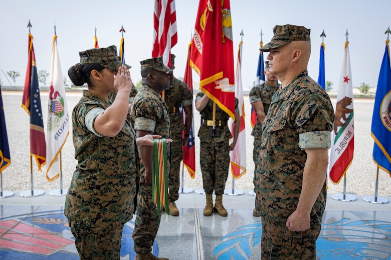 U.S. Marine Corps Sgt. Natalie Cesar, a legal services specialist with U.S. Marine Corps Forces Korea, presents a meritorious unit commendation streamer to Maj. Gen. William E. Souza III, commander of MARFORK, during the MARFORK 30th anniversary and colors and rededication ceremony at U.S. Army Garrison Humphreys, South Korea, May 29, 2025. MARFORK was activated on June 1, 1995, at Seoul, Republic of Korea to support U.S. Marine Corps operations, strengthen interoperability with the Republic of Korea Marine Corps and serve as the U.S. Marine Corps service component for United States Forces Korea and United Nations Command. (U.S. Marine Corps photo by Cpl. Nikolas Mascroft)