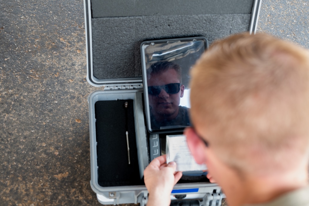 Airman checks a reference card
