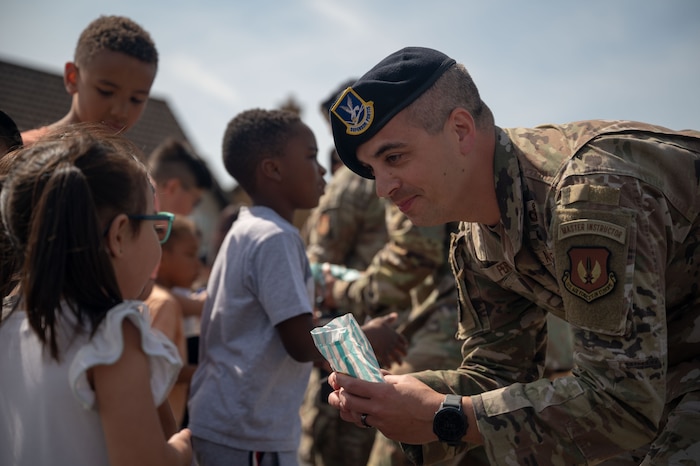 military member handing out candy to families