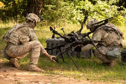 U.S. Army Specialist Nicholas Chiara (left), a unmanned aircraft system operator, and Staff Sgt. Richard Levanti, a unmanned aircraft system operator, assigned to 2-7 Infantry Battalion inspect the carrier H6 during Combined Resolve 25-2 in Hohenfels, Germany, May 20, 2025.