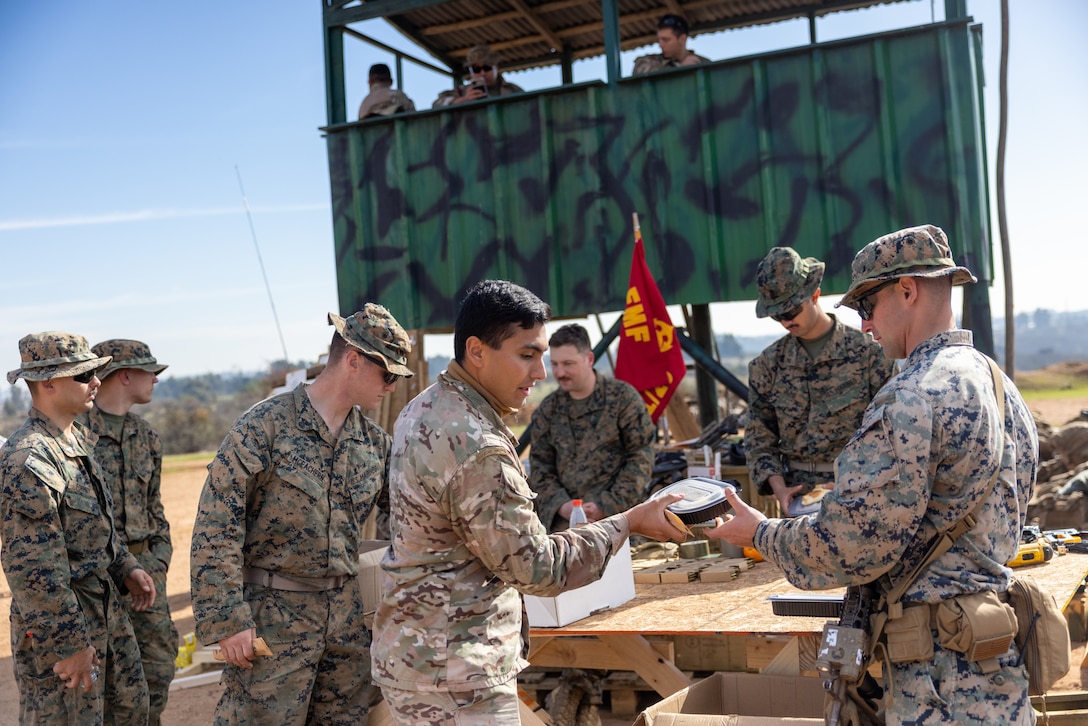 U.S. Marines with 1st Battalion, 25th Marines, 4th Marine Division and Chilean Marines, eat together during a break from a live fire exercise during Southern Star 25, at Fuerte Aguayo, Chile, May 29, 2025. Southern Star is a multinational training exercise emphasizing operational and tactical missions, bringing together joint, combined, interagency, and military forces to strengthen coordination and interoperability within a unified special operations command. (U.S. Marine Corps photo by Lance Cpl. Payton Goodrich)