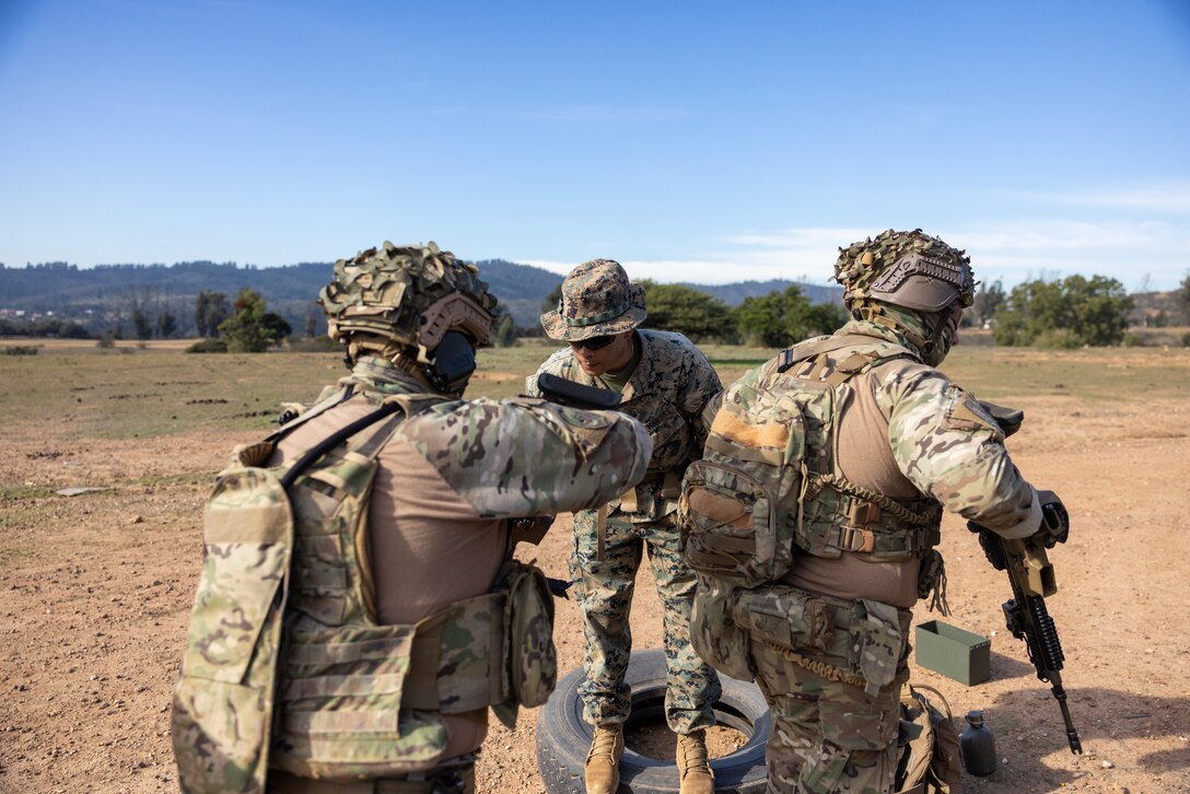 A U.S. Marine with 1st Battalion, 25th Marines, 4th Marine Division clears out and checks the rifles of Chilean marines before they enter the range to participate in a live fire exercise during Southern Star 25, at Fuerte Aguayo, Chile, May 29, 2025. Southern Star is a multinational training exercise emphasizing operational and tactical missions, bringing together joint, combined, interagency, and military forces to strengthen coordination and interoperability within a unified special operations command. (U.S. Marine Corps photo by Lance Cpl. Payton Goodrich)