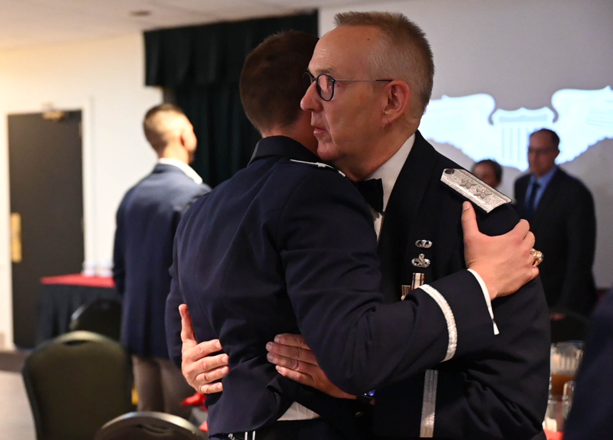 Retired U.S. Air Force Maj. Gen. Duane A. Jones embraces a newly graduated pilot at Laughlin Air Force Base, Texas, May 29, 2025.  Loved ones in attendance pinned pilot wings to graduates as a representation of completing undergraduate pilot training. (U.S. Air Force photo by Airman 1st Class Darryl Keith.)
