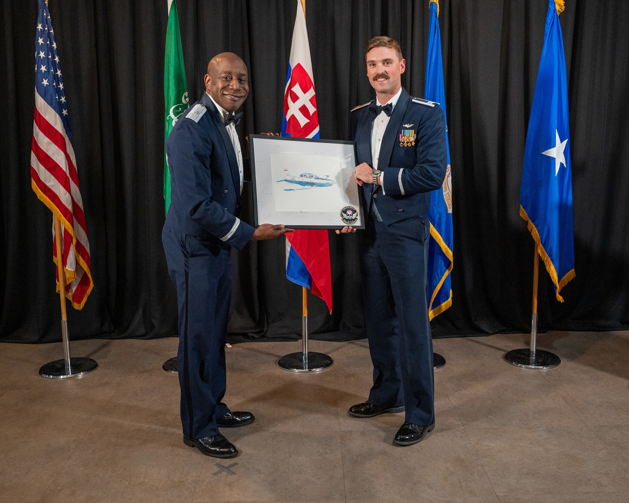 U.S. Air Force Capt. Jacob Anderson, right, 47th Student Squadron student pilot, presents a token of appreciation to Brig. Gen. Travolis Simmons, left, director of training and readiness, deputy chief of staff for operations at Headquarters U.S. Air Force, at Laughlin Air Force Base, Texas, May 29, 2025. Brig. Gen. Simmons spoke at the graduation of Class 25-10 about how new pilots will have immediate responsibilities as they go out to the Air Force. (U.S. Air Force photo by Staff Sgt. Nicholas Larsen)