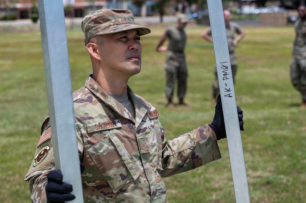Image of an Airman putting up a structure.