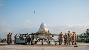 U.S. Airmen stnad around a fight jet