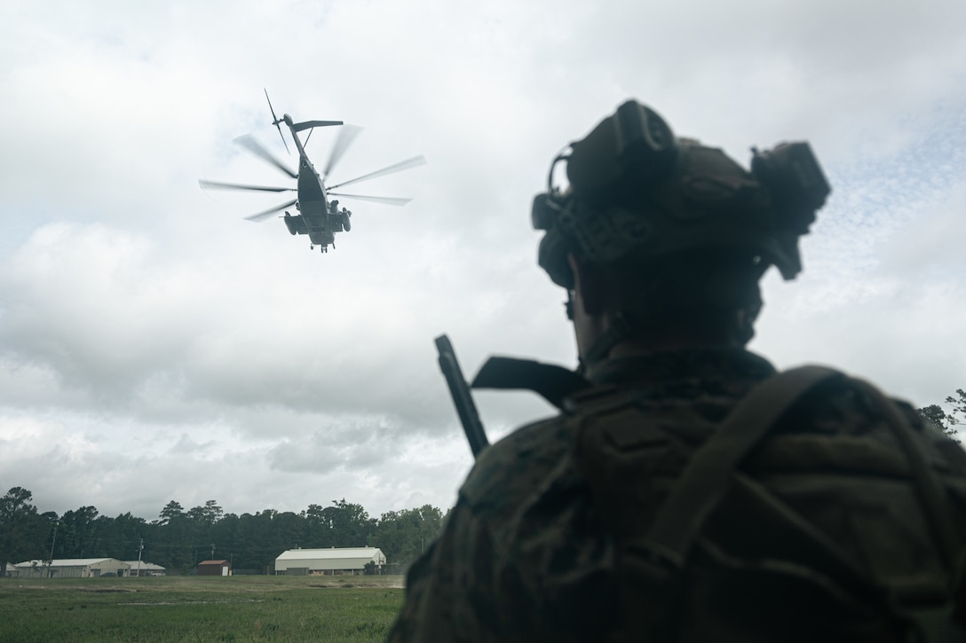 U.S. Marine Corps Sgt. Dennis McNabb, a squad leader with Lima Company, Battalion Landing Team 3/6, 22nd Marine Expeditionary Unit, observes a CH-53E Super Stallion prepare for landing during a simulated non-combatant operation, as part of Iwo Jima Amphibious Ready Group Marine Expeditionary Unit exercise, at Marine Corps Base Stone Bay, North Carolina, May 28, 2025. During ARGMEUEX, the 22nd MEU, aboard IWOARG shipping, conducts various mission essential tasks that enhance operational readiness and lethality as a unified IWOARG/22 MEU team. (U.S. Marine Corps photo by Cpl. Maurion Moore)