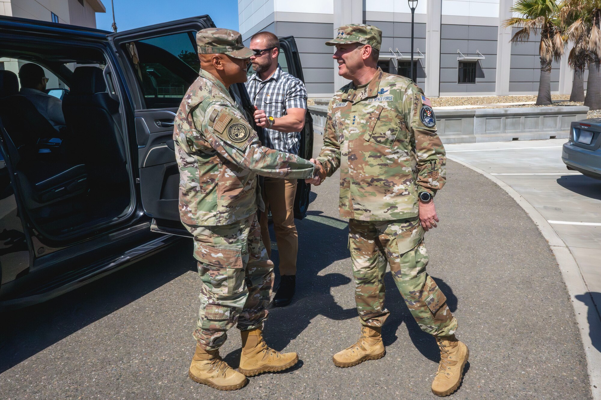 Two senior military members greet each other.