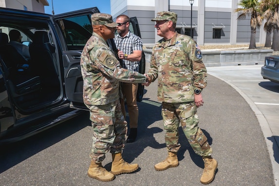 Two senior military members greet each other.