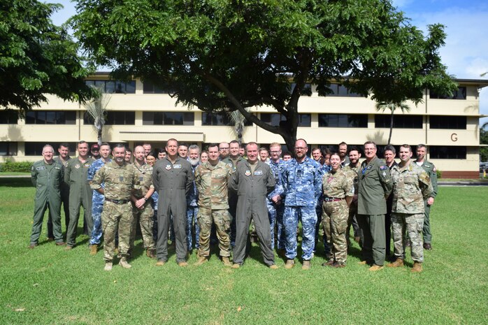 :  Royal Air Force, Royal Australian Air Force and United State Air Force members stand outside of a building
