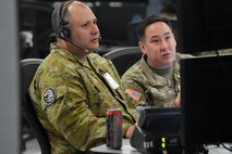 uniformed coalition and US military members work on computers