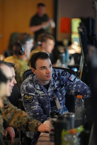 Australian and U.S. military members work at computers