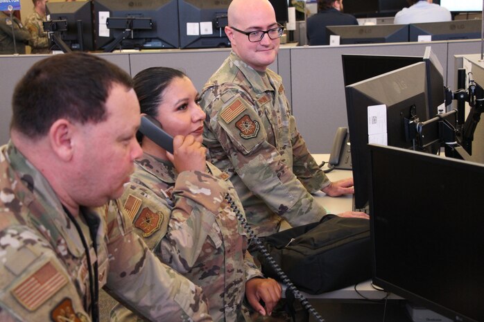 uniformed U.S. Airmen work on computers