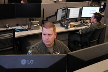 uniformed U.S. Airmen work on computers