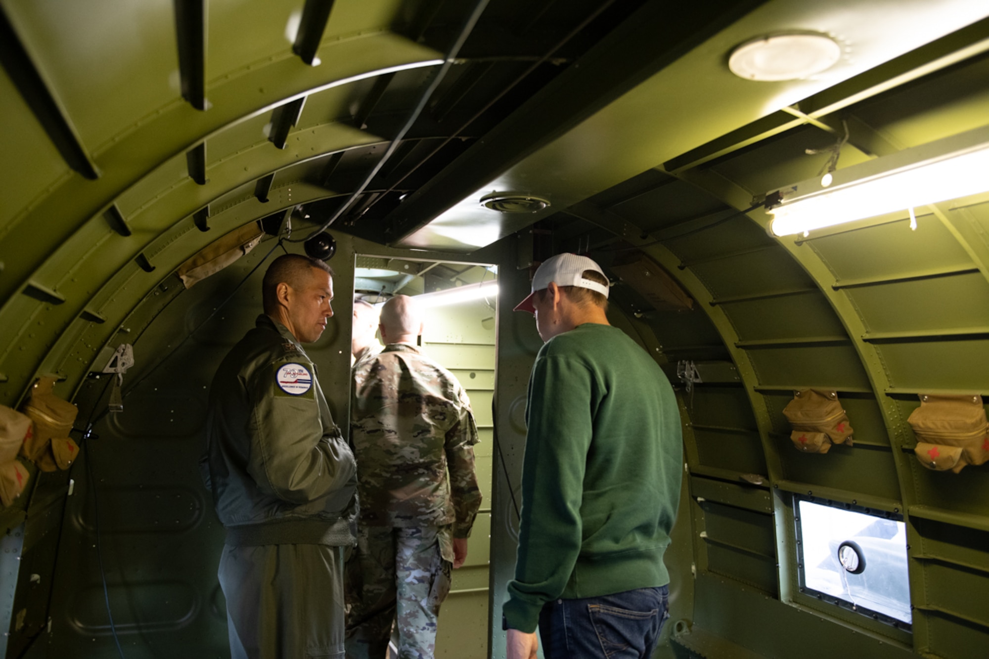 Airmen standing inside C-47 Night Fright touring the resotration project.