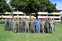 :  Royal Air Force, Royal Australian Air Force and United State Air Force members stand outside of a building