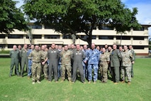 :  Royal Air Force, Royal Australian Air Force and United State Air Force members stand outside of a building