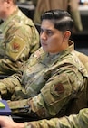 uniformed U.S. Air Force Airmen stand around conference table