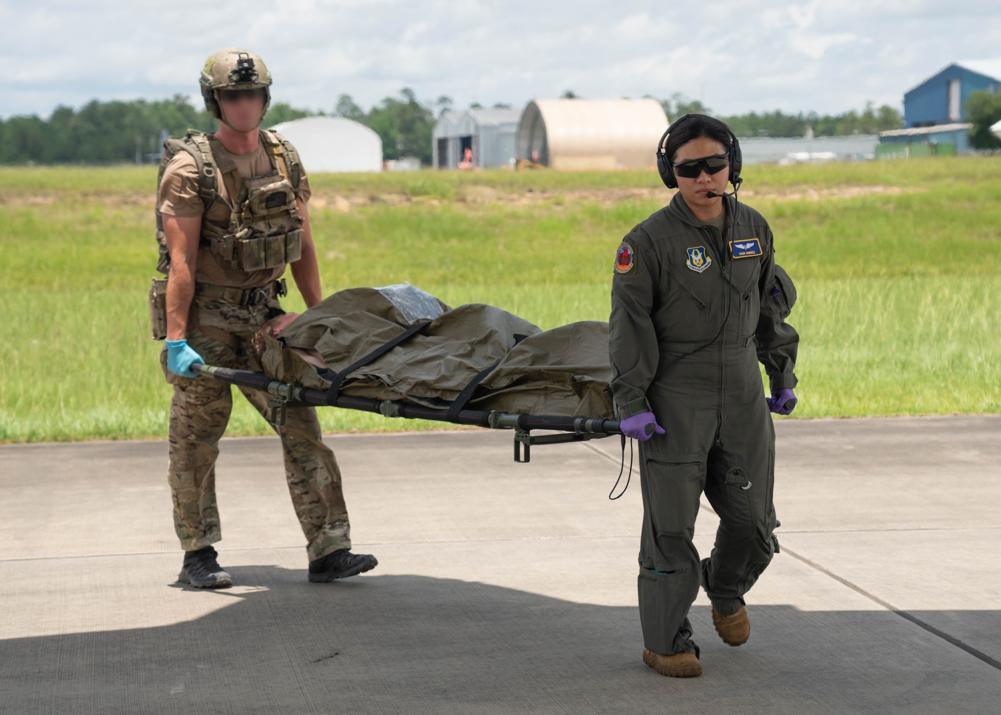 military members carrying litter with patient.