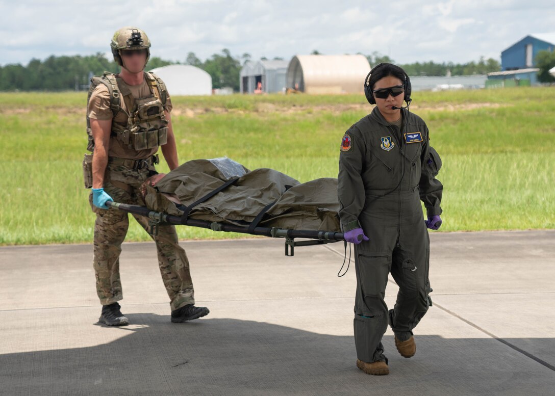 military members carrying litter with patient.