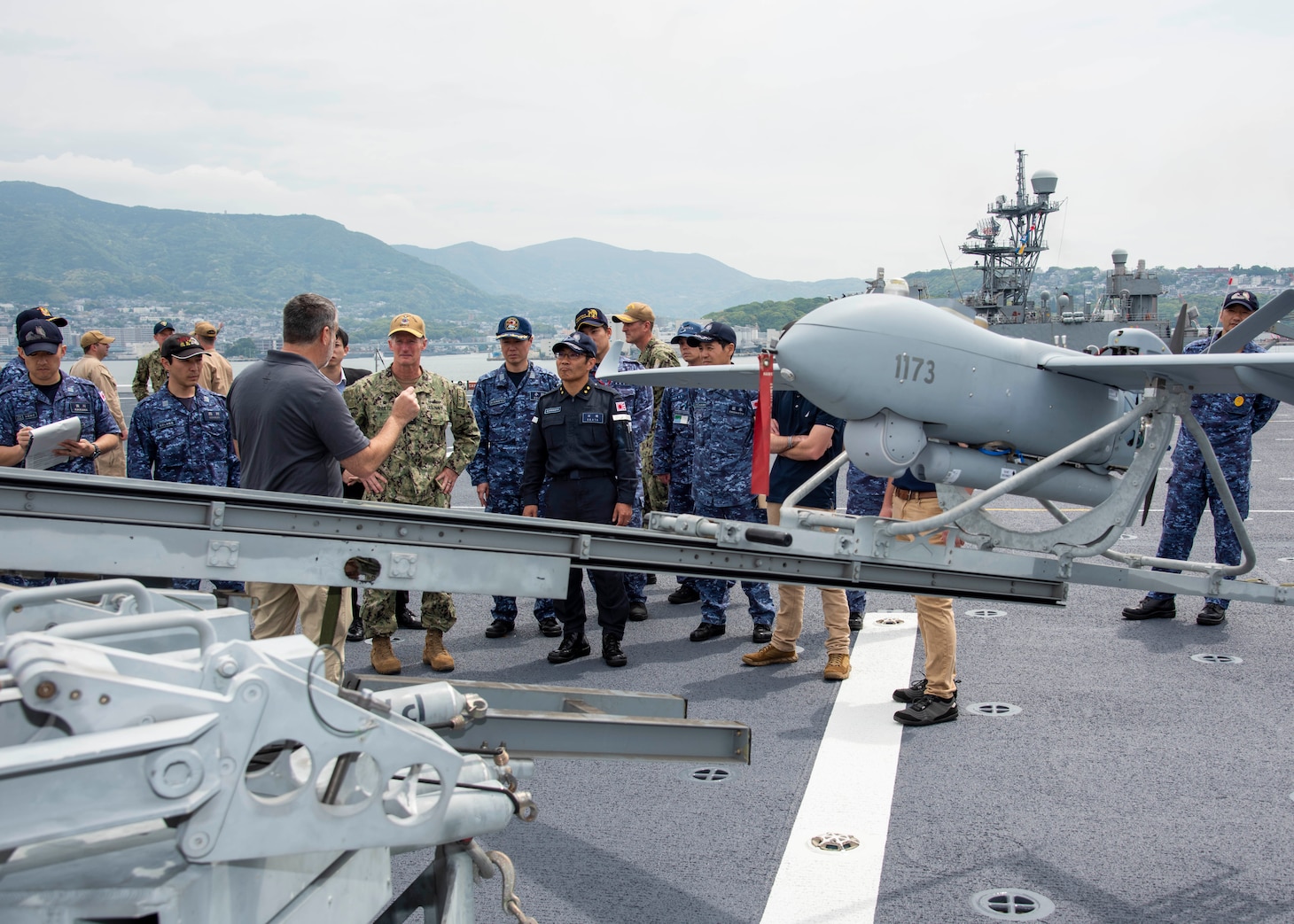 SASEBO, Japan (May 15, 2025) – Jeffery Wyatt, a member of Textron Systems, describes the capabilities of the Aerosonde MK 4.7 unmanned aerial system to Japan Maritime Self-Defense Force Rear Adm. Yatsutaka Ebata, commander, Escort Flotilla 2, and Rear Adm. Tom Shultz, commander, Task Force (CTF) 76, during the Integrated Battle Problem 25.5 technology demonstration aboard the Lewis B. Puller-class Expeditionary Sea Base USS Miguel Keith (ESB 5), at Commander, Fleet Activities Sasebo, Japan, May 15, 2025. Exercises, such as Integrated Battle Problem, allow the Navy to demonstrate unmanned system operations in relevant experiment scenarios in order to meet service level objectives and operationalize unmanned systems and capabilities to maintain a secure and prosperous Indo-Pacific region. U.S. 7th Fleet, the U.S. Navy’s largest forward-deployed numbered fleet, routinely interacts and operates with allies and partners in preserving a free and open Indo-Pacific region. (U.S. Navy photo by Mass Communication Specialist 1st Class W. Chase Stephens)