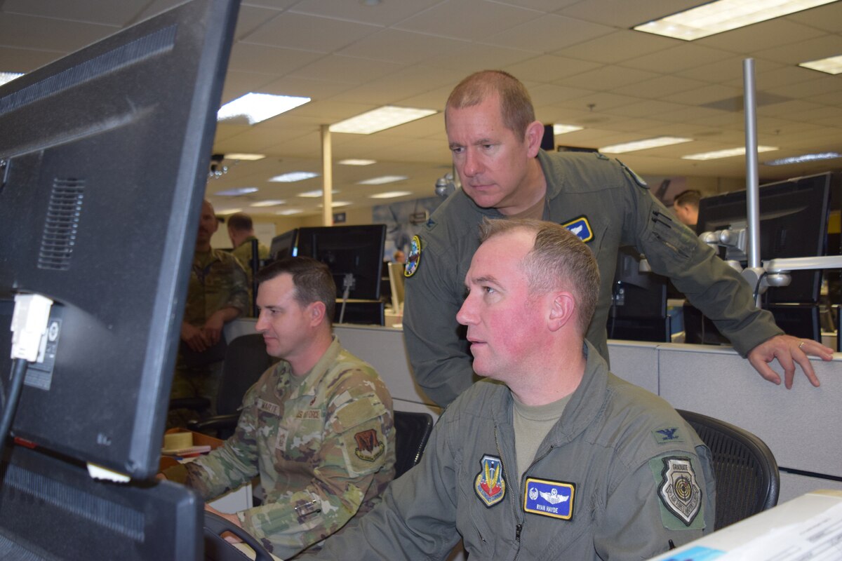 uniformed U.S. Airmen work on computers