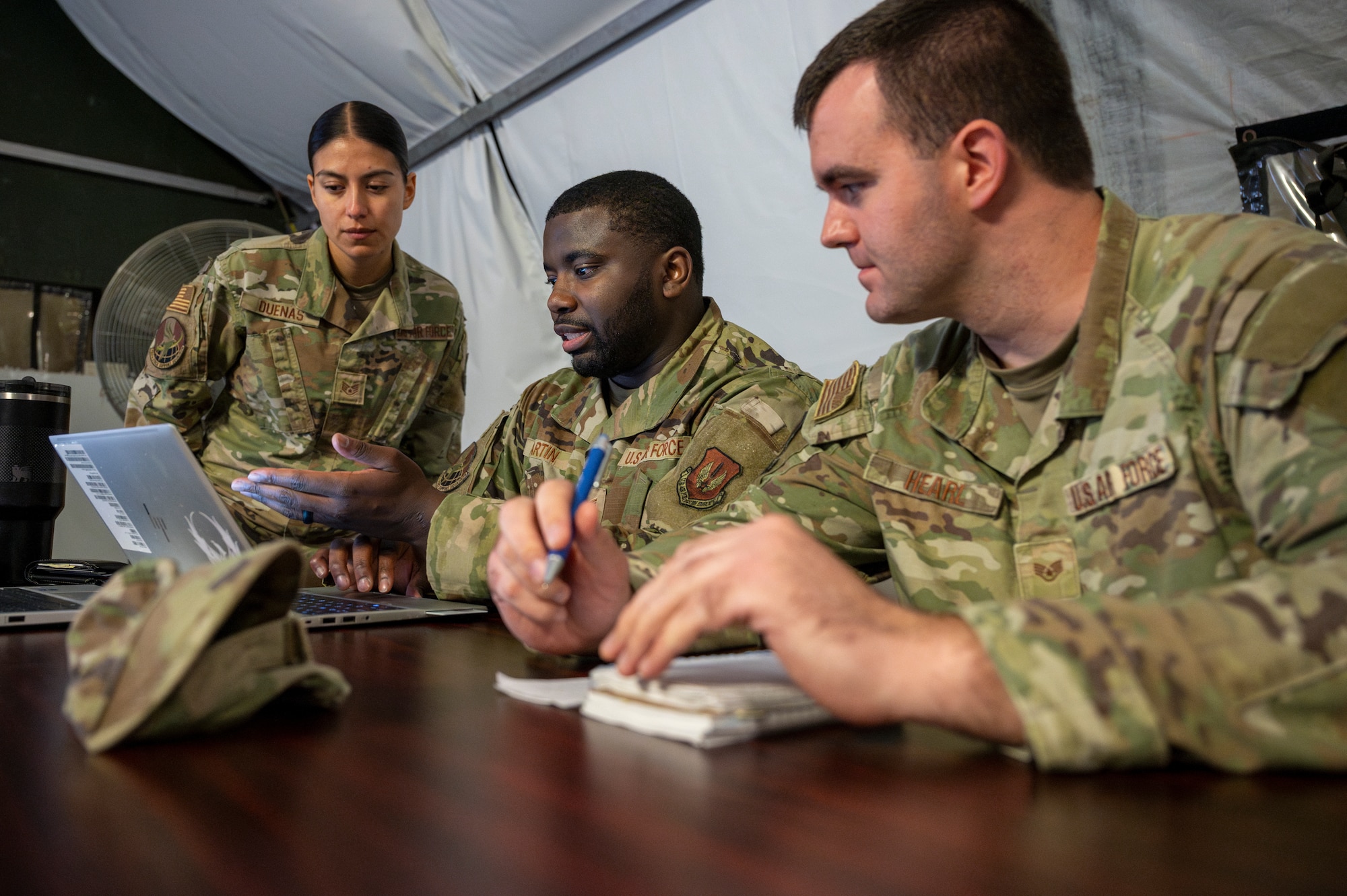 U.S. Air Force Staff Sgt. Alondra Duenas, 786th Force Support Squadron noncommissioned officer in charge of base relocations and promotions, Tech. Sgt. Melchizedek Martin, 786th FSS noncommissioned officer in charge of force management, and Staff Sgt. Hearl, 786th FSS readiness and plans craftsman, plan the setup of a Personnel Support for Contingency Operation (PERSCO) line during Operation Steel at the 435th Construction and Training Squadron Compound near Ramstein Air Base, Germany, May 28, 2025.