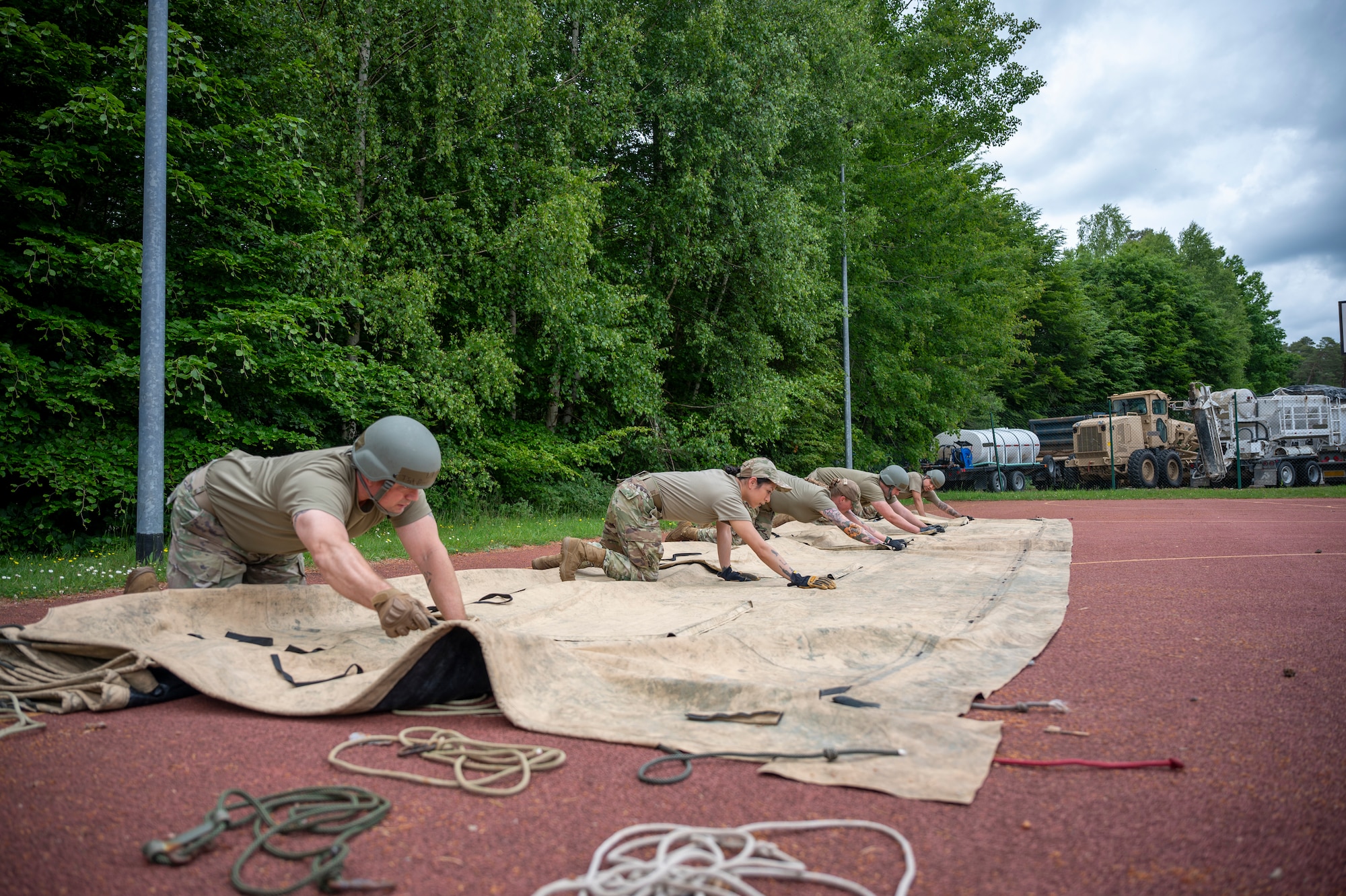 U.S. Airmen from the 786th Force Support Squadron fold a Single Pallet Expeditionary Kitchen (SPEK) tarp during Operation Steel at the 435th Construction and Training Squadron Compound near Ramstein Air Base, Germany, May 29, 2025.