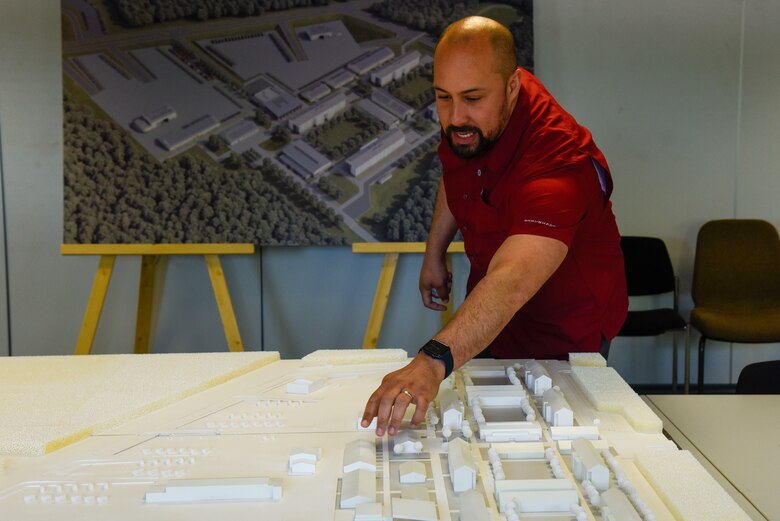 man pointing to 3D model on a table
