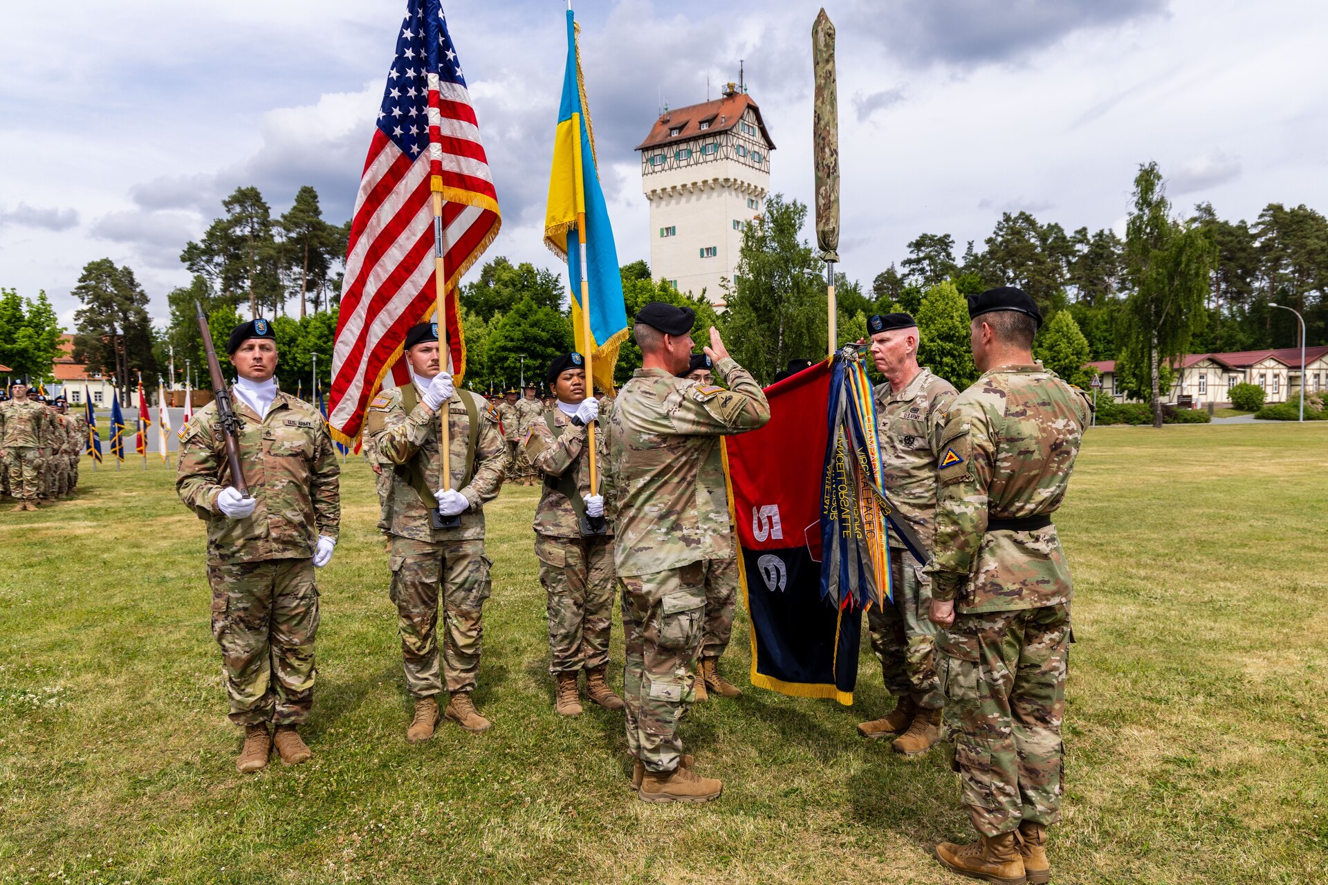 The uncased 56th Stryker Brigade Combat Team unit colors lower as U.S. Army Brig. Gen. Steven Carpenter, commanding general of the 7th Army Training Command; Col. Christopher Costello, commander of the 56th SBCT; and Command Sgt. Maj. James Short, command sergeant major of the 56th SBCT, all render a salute during the Joint Multinational Training Group-Ukraine transfer of authority ceremony at Tower Barracks, Grafenwoehr, Germany, June 1, 2025. The ceremony commemorated the transfer of the JMTG-U mission from the 56th SBCT to the 278th Armored Cavalry Regiment, Tennessee National Guard. (U.S. Army National Guard photo by Capt. Leanne Demboski)