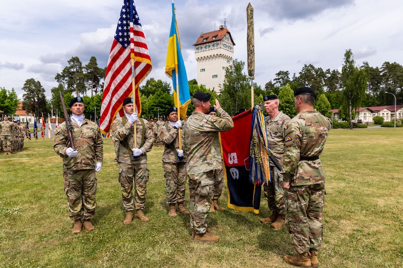 The uncased 56th Stryker Brigade Combat Team unit colors lower as U.S. Army Brig. Gen. Steven Carpenter, commanding general of the 7th Army Training Command; Col. Christopher Costello, commander of the 56th SBCT; and Command Sgt. Maj. James Short, command sergeant major of the 56th SBCT, all render a salute during the Joint Multinational Training Group-Ukraine transfer of authority ceremony at Tower Barracks, Grafenwoehr, Germany, June 1, 2025. The ceremony commemorated the transfer of the JMTG-U mission from the 56th SBCT to the 278th Armored Cavalry Regiment, Tennessee National Guard. (U.S. Army National Guard photo by Capt. Leanne Demboski)