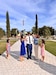 Wife and daughters of male Soldier pin his rank during his promotion ceremony. Ceremony is outside on a sunny day.
