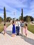 Wife and daughters of male Soldier pin his rank during his promotion ceremony. Ceremony is outside on a sunny day.