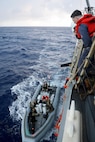 Coast Guardsmen assigned to U.S. Coast Guard Law Enforcement Detachment (LEDET) 401, and Sailors assigned to the Arleigh Burke-class guided-missile destroyer USS Gravely (DDG 107), prepare to transfer bails of cocaine seized during a maritime interdiction operation (MIO) while underway in the Caribbean Sea.