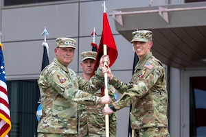 U.S. Space Force Lt. Gen. Douglas Schiess, left, U.S. Space Forces—Space commander and Combined Joint Force Space Component commander, passes the guidon to USSF Col. Bryan Bell, right, incoming Space Delta 15 commander and National Space Defense Center director, during a change of command ceremony at Schriever Space Force Base, Colo., June 2, 2025. Bell assumes command of DEL 15 and responsibilities as director of the NSDC after two years as a Senior Operations Research Analyst in the Oﬃce of the Secretary of Defense’s Cost Assessment and Program Evaluation and brings with him a diverse background spanning air, space, and cyberspace operations. (U.S. Space Force photo by Dalton Prejeant)