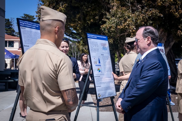 Secretary of the Navy John C. Phelan speaks with students about their research projects during a visit to the Naval Postgraduate School, May 29.