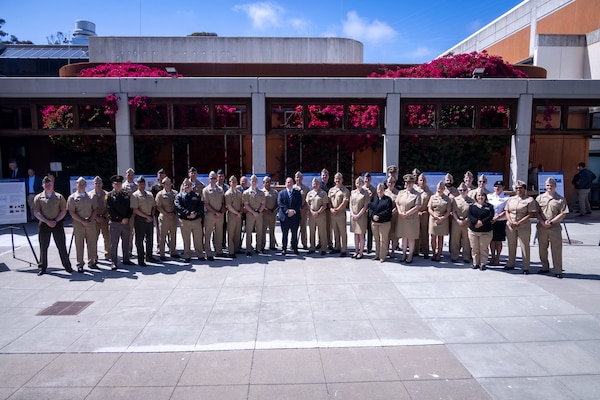 Secretary of the Navy John C. Phelan poses with Naval Postgraduate School (NPS) students for a group photo during a visit to the NPS, May 29.