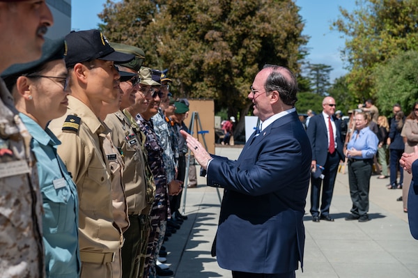 Secretary of the Navy John C. Phelan speaks with allied military and partner nation students at the Naval Postgraduate School (NPS) about their research projects during a visit to NPS, May 29.