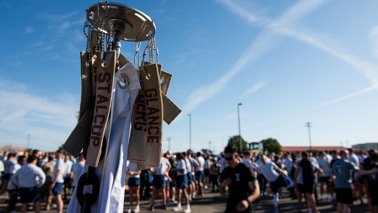 Flagpole in the foreground as Airmen get ready for run