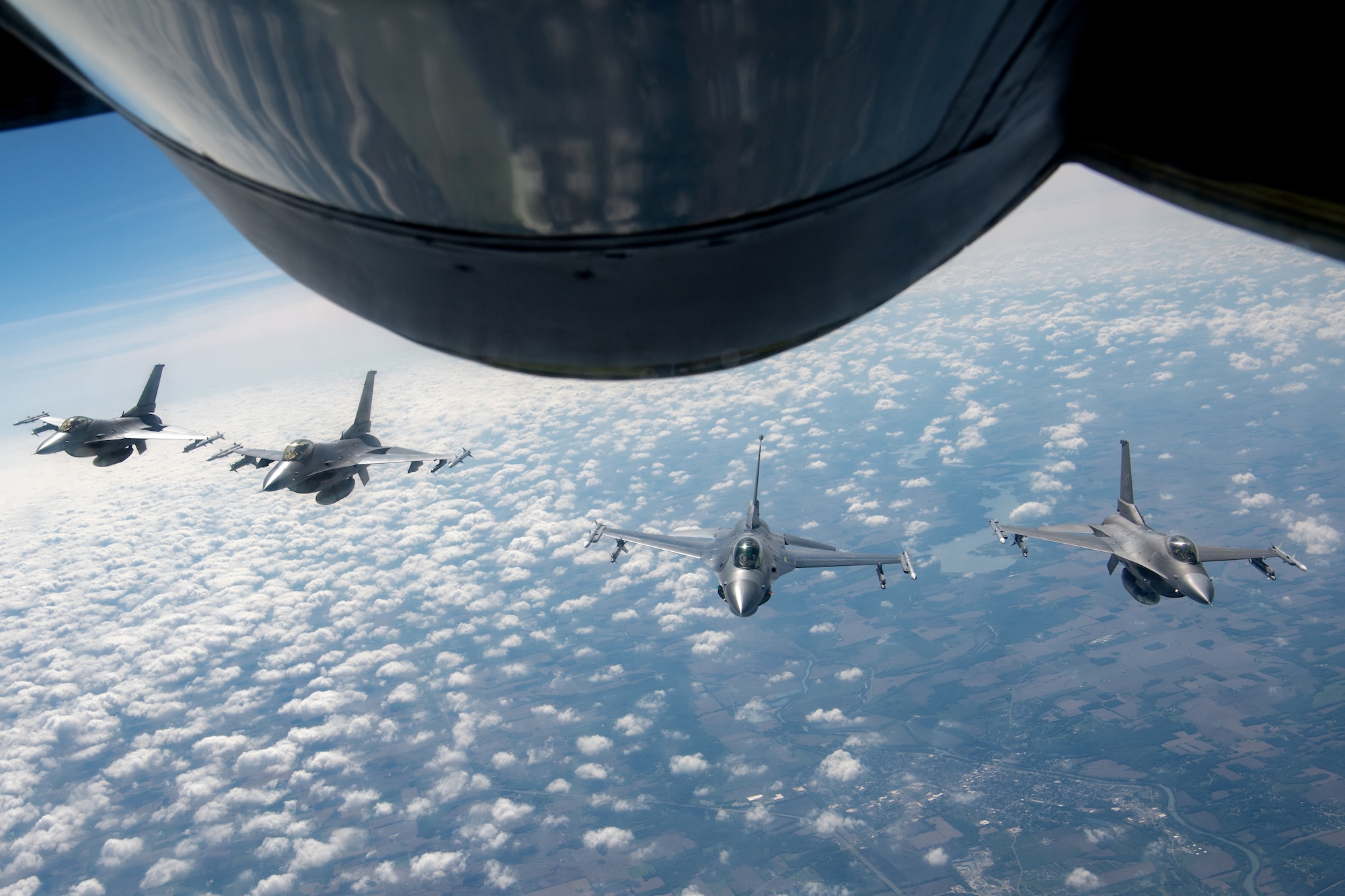 Four F-16 Fighting Falcons from the 122nd Fighter Wing, Fort Wayne, Ind., fly in formation behind a KC-135R Stratotanker from the 434th Air Refueling Wing, Grissom Air Reserve Base, Ind., over central Indiana May 29, 2025. The display of power demonstrates the joint relations between state Guardsman and Reserve citizen Airmen that ensure the protection of our nation both stateside and abroad. (U.S. Air Force photo/Ben Mota)