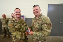 Brig. Gen. Brian A. Filler, Director of Security Forces, Deputy Chief of Staff for Logistics, Engineering and Force Protection, Headquarters U.S. Air Force, presented his general officer coin to U.S. Air Force Senior Airman Colbie Jones, 433rd Security Forces Squadron fire team member, during a tour of the 433rd SFS at Joint Base San Antonio-Lackland, Texas, May 3, 2025.
