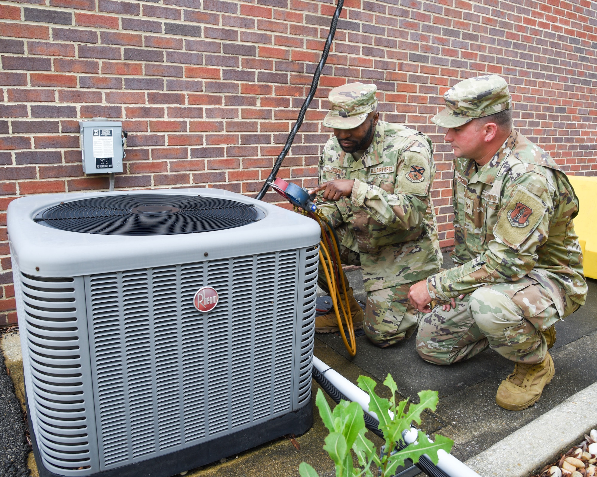 U.S. Air Force personnel conduct a maintenance check on HVAC equipment.