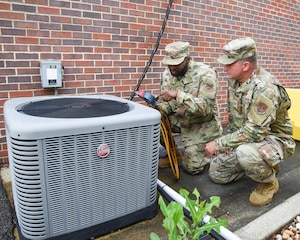 U.S. Air Force personnel conduct a maintenance check on HVAC equipment.