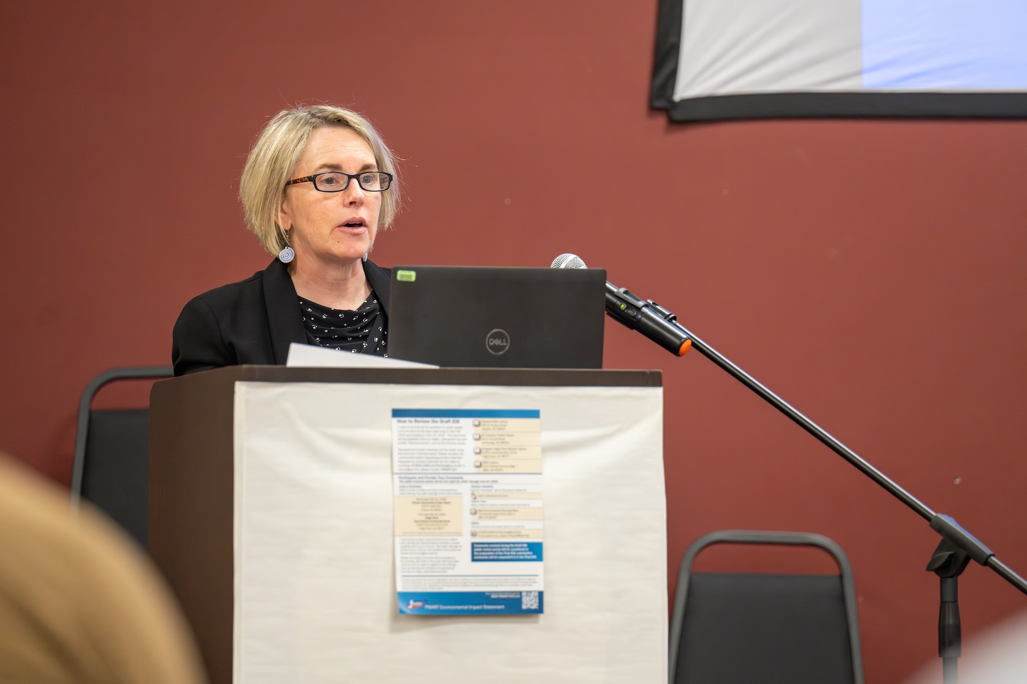 Tara Bellion, a contractor from Architecture, Engineering, Construction, Operations and Management, speaks to an audience at the Proposed Mortar and Artillery Training Environmental Impact Statement public hearing at Eagle River, Alaska.