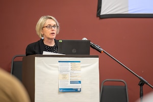Tara Bellion, a contractor from Architecture, Engineering, Construction, Operations and Management, speaks to an audience at the Proposed Mortar and Artillery Training Environmental Impact Statement public hearing at Eagle River, Alaska.