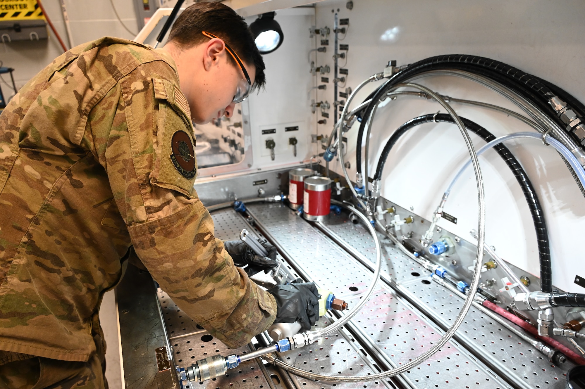 Airman inspects aircraft part.